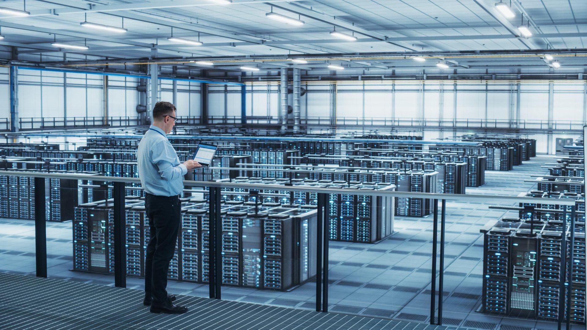 Man standing with plenty of computers in room